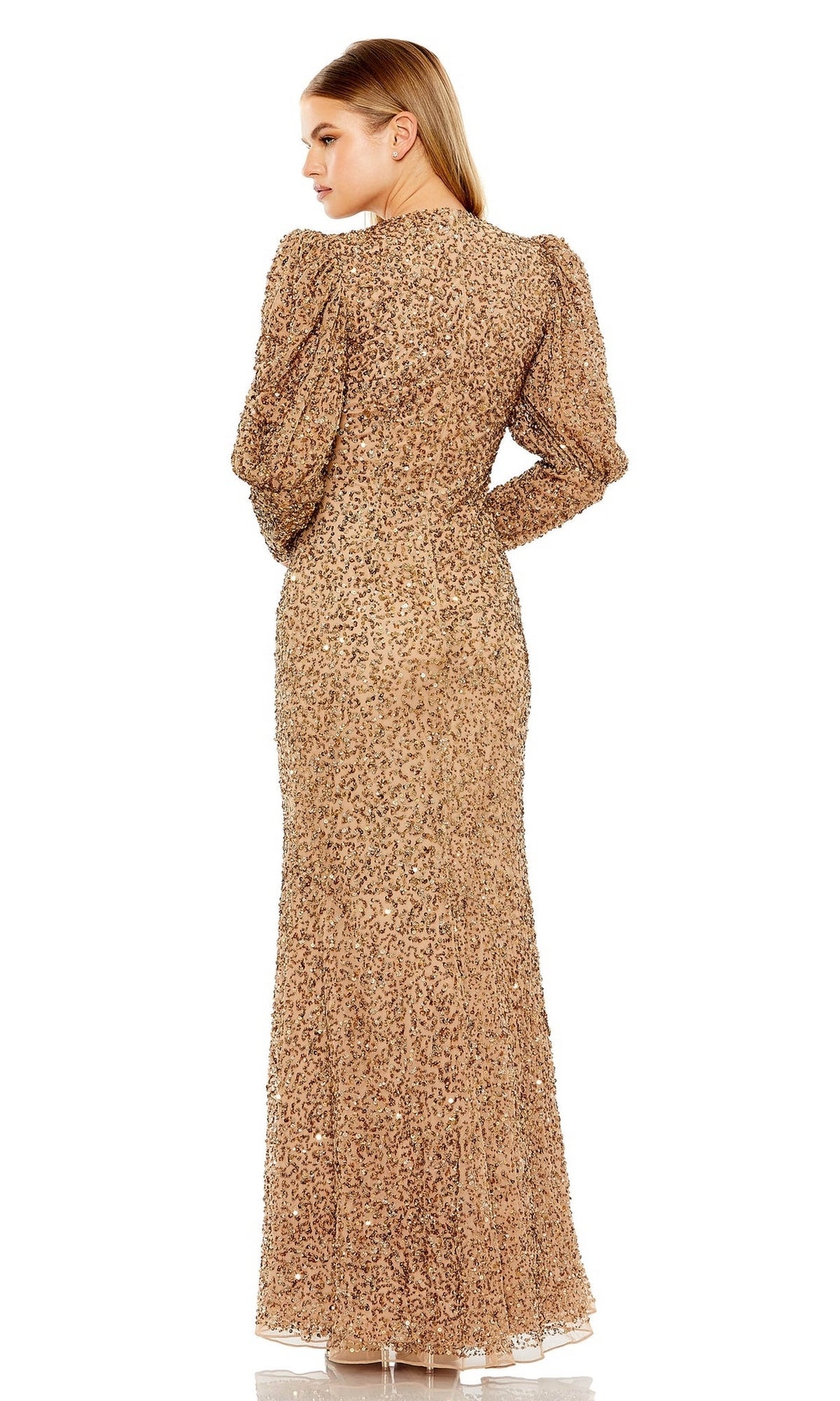 A woman stands with her back to the camera, wearing the Long Formal Dress 24000 by Mac Duggal—a long, gold, patterned gown featuring long sleeves and a high neckline.